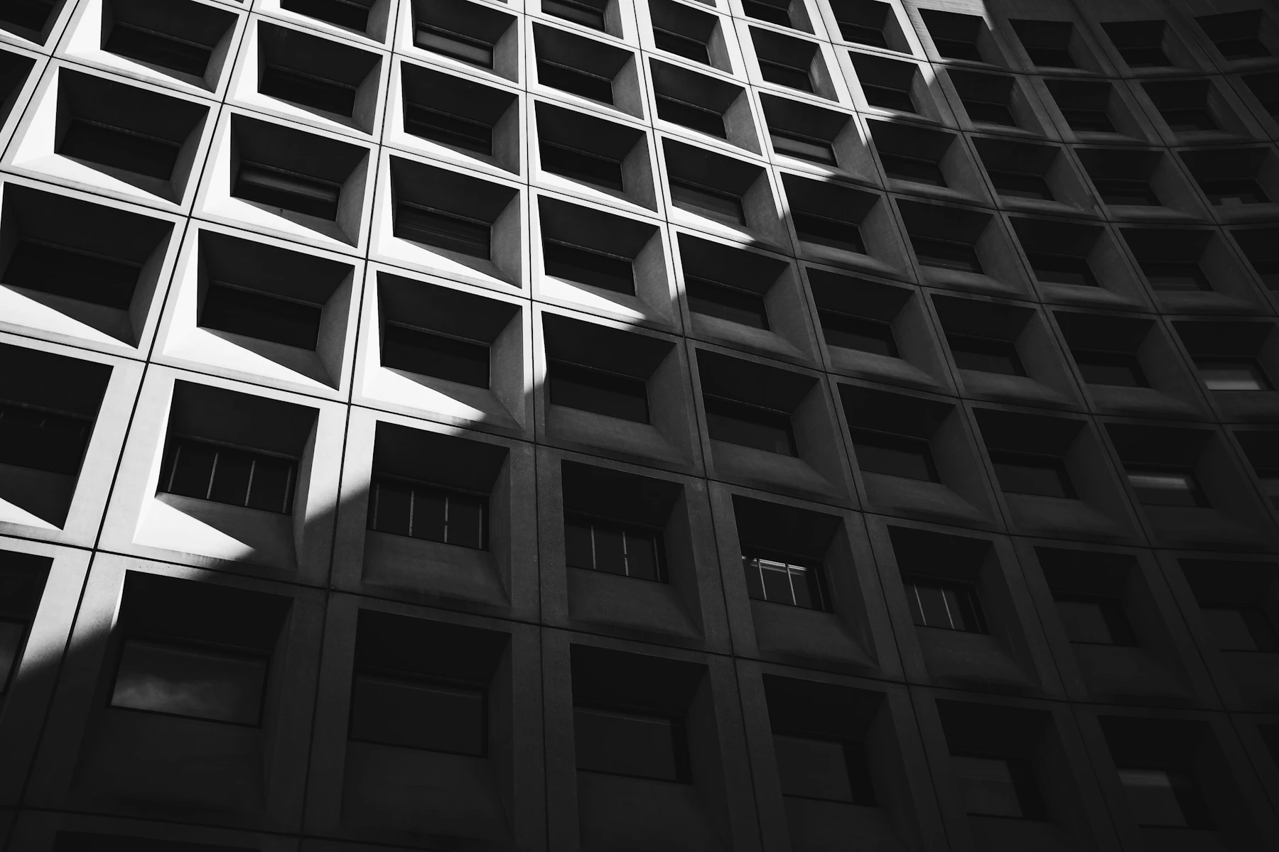 Deep-relief modular façade grid catching low sunlight