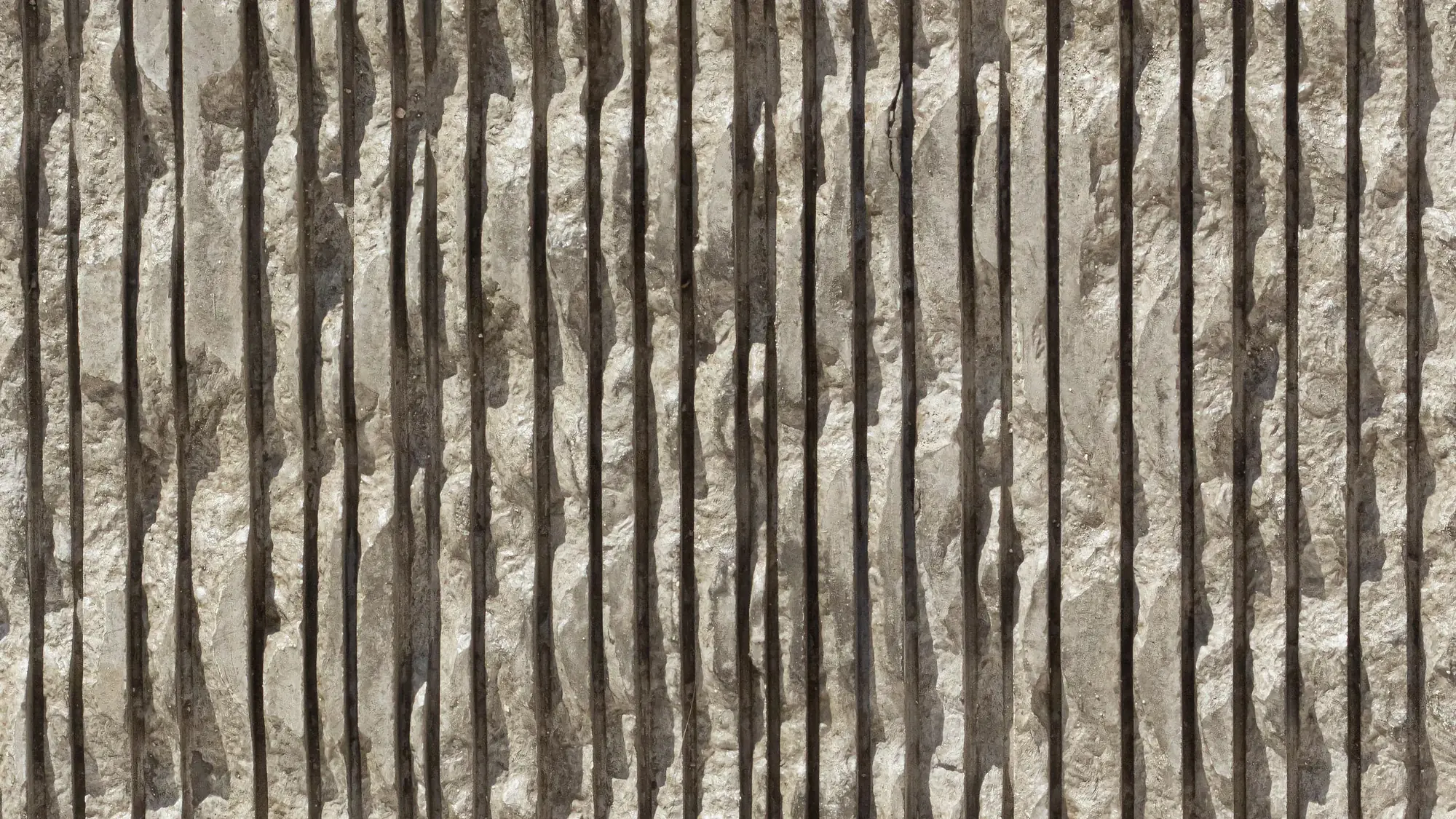 Marmo Vein surface in raking light — closely spaced vertical ribs broken along their length