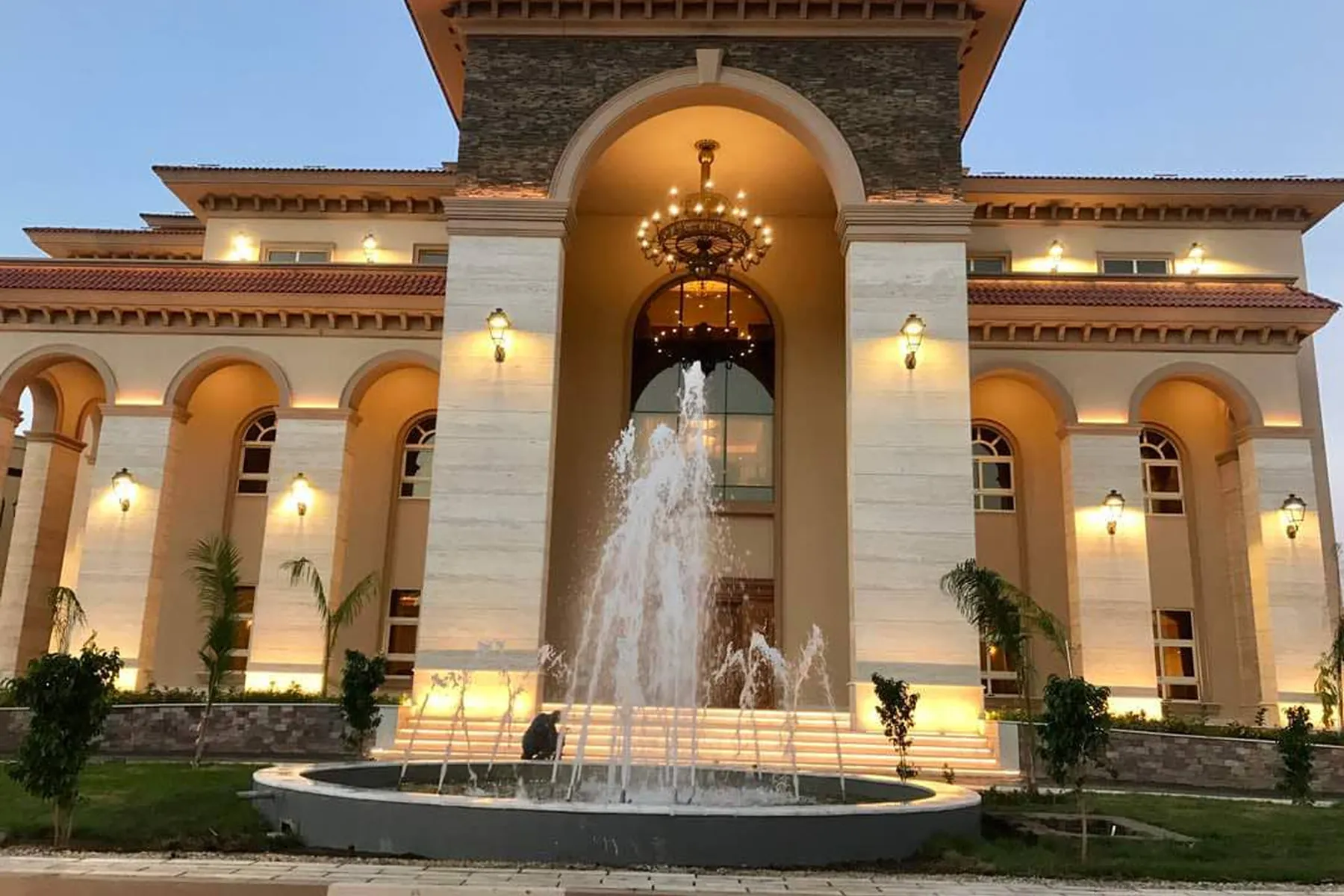 Al-Diyafah Palace — lit entrance portico above the forecourt fountain